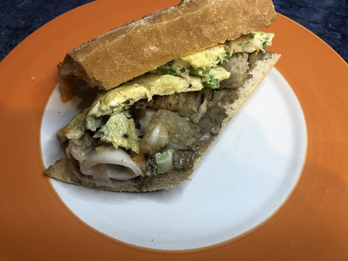 Bocadillo de calamares con alioli de ajo negro y revuelto de ajetes