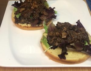 Carne desmechada servida en una hamburguesa con lechuga