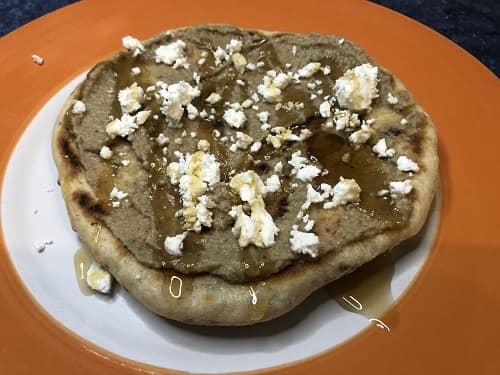 Pan de pita o árabe emplatado con baba ganoush, queso feta y miel