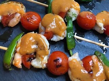 Salsa americana utilizada para condimentar unas brochetas de gambas con tomates cherry y pimientos del padron