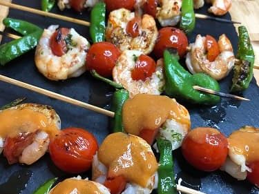 Salsa americana utilizada para condimentar unas brochetas de gambas con tomates cherry y pimientos del padron