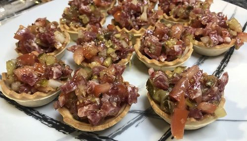 Tartar de fuet servido en una tartaleta