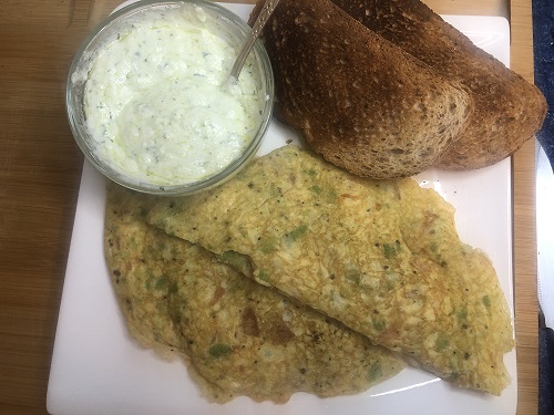 Tortilla de aguacate y tomate con dos rebanadas de pan y salsa de yogurt casera