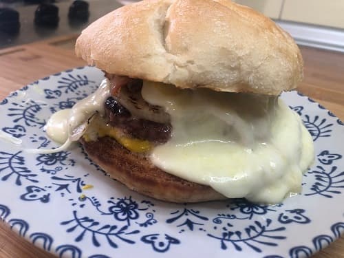 Hamburguesa con abundante queso y cebolla caramelizada.