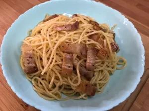 Carbonara fácil. Plato de espaguetis con panceta y yema de huevo.