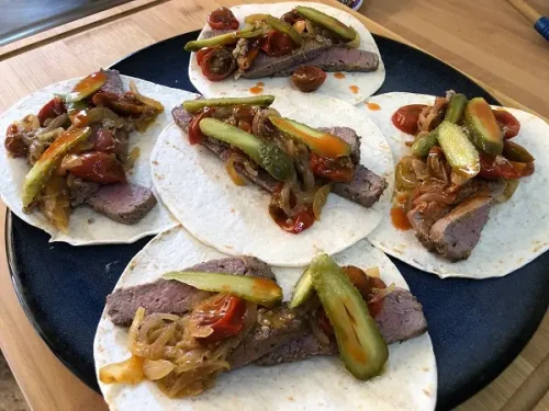 Tacos mexicanos con ternera, cebolla, tomatitos y pepinillos en vinagre