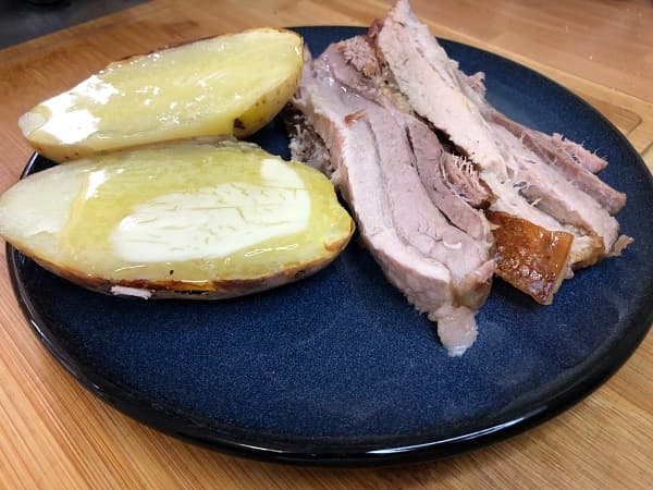 Filetes de panceta asada al horno con patatas.